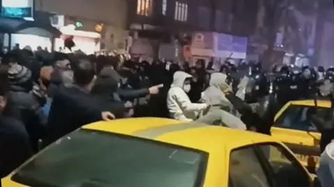 Large crowds in street at night protesting