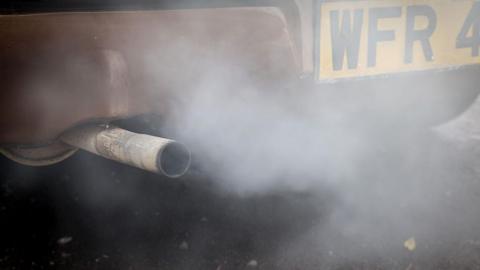 Fumes are seen leaving the exhaust pipe of an old Ford Cortina car.