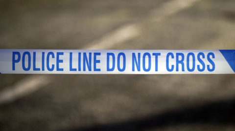 A blue and white police tape with the word: 'POLICE LINE DO NOT CROSS'