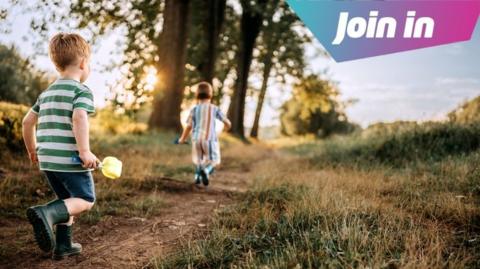 Two boys walking, one a few metres in front of the other.