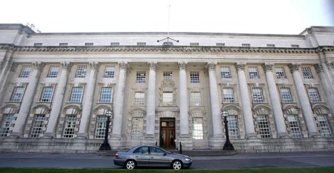 A wide shot of the Royal Courts of Justice in Belfast - a portland stone building of four storeys with a series of pillars and windows