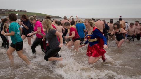 Participants run from the sea as they take part in the annual New Year's Day swim at Barry Island as several hundred swimmers marked start of 2016 by taking a dip in the sea in Whitmore Bay on January 1, 2016 in Barry, Wales. 