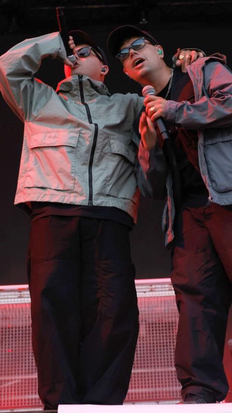 Two member of Kneecap on stage singing into microphones 
