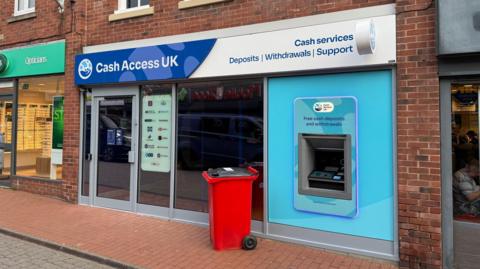 A shop front which reads CASH ACCESS UK CASH SERVICES DEPOSITS WITHDRAWALS SUPPORT