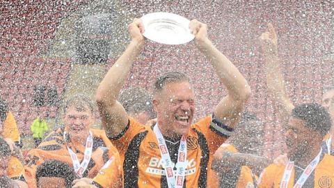 Cambridge United captain Michael Morrison lifts the League Two trophy