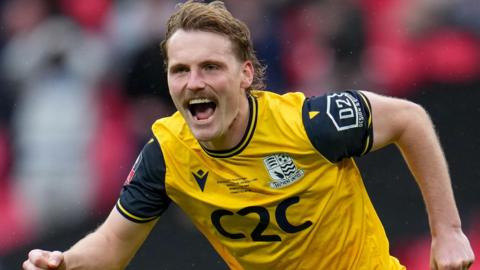 Gus Scott-Morriss celebrates scoring the winning penalty in the shootout against Wealdstone in the FA Trophy final