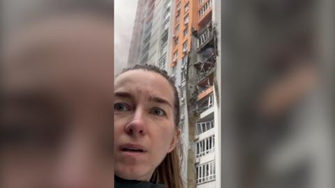 BBC Ukrainian Journalist Anastasiya Gribanova standing outside her apartment block which was hit during overnight Russian strikes