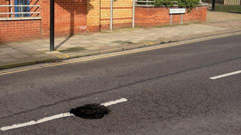 A sink hole in the centre of a road