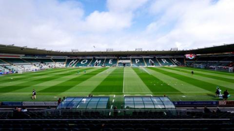 A picture taken from the side of home park stadium. It is a large stadium with grass in the middle 