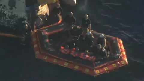 The Astronauts in orange spacesuits floating in the ocean with other crew members