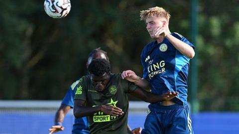 Thomas Wilson-Brown (right) winning a header in a friendly against Belgian side Leuven