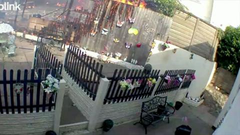 A garden fence on fire in a back garden