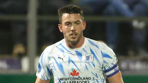 Captain Niall Canavan playing for Barrow on a wild and windy nigh at Holker Street 