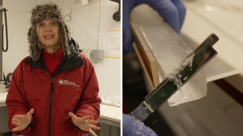 A woman in a large red coat wearing woolly trapper hat next to a pole of ice being shaved with a metallic tool