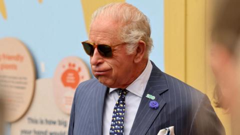 Britain's King Charles feels the heat during a visit to the humid climate of the “Giants of the Galapagos” enclosure at ZSL London Zoo which he visited with the Queen