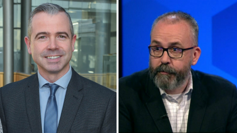 A composite image of Pól Deeds and Lee Reynolds. On the left is Pól Deeds, who has short grey hair and facial hair. He is wearing a dark grey suit, blue shirt and dark blue tie. He is smiling at the camera and appears to be standing in an office building. On the right is Lee Reynolds, who is an older, balding man, with a dark beard and glasses. He is looking to his right and is wearing a black suit jacket and white checkered shirt.
