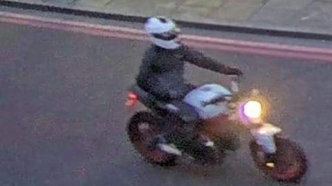 CCTV image of motorcyclist wanted by police showing them riding the white Ducati Monster bike