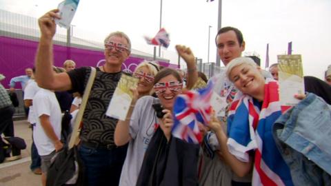 Ticket holders wearing union jack clothing wave to the camera. 