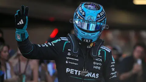 Mercedes' George Russell waves in celebration after taking pole position for the Barcelona-Catalunya Grand Prix