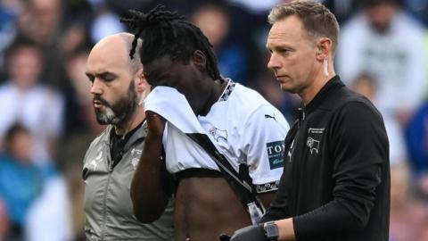 David Ozoh covers his face in disappointment as he comes off the field because of injury