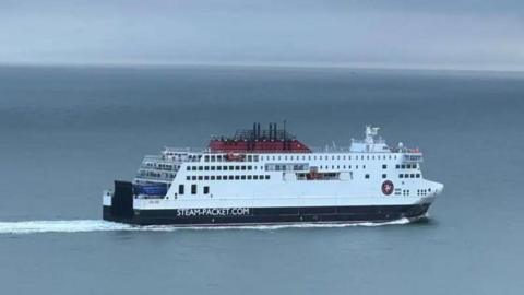 The Manxman, a large white and navy ferry, it is making a journey across a calm sea.