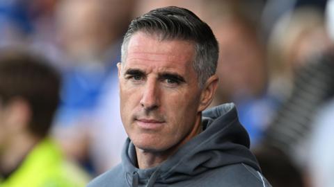 Swindon Town head coach Mark Kennedy looks on during his side's League Two fixture against Chesterfield in August 2024