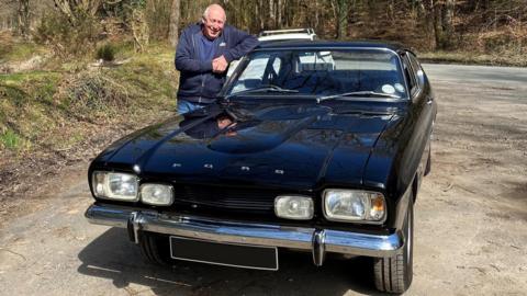 A modern picture of Mr Doyle stood by his Capri. 