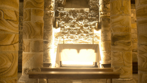 The medieval stonework columns of the Norman Chapel with light streaming through previously buried windows