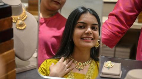 A woman buys gold jewellery on the occasion of Akshaya Tritiya festival in Ahmedabad on April 19, 2026. (Photo by Shammi MEHRA / AFP via Getty Images)