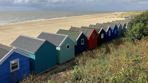 Colourful beach huts next to the coast in Southwold, Suffolk