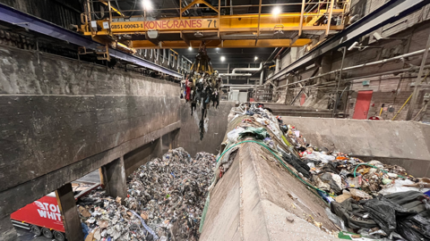 A crane manoeuvres rubbish in a recycling centre