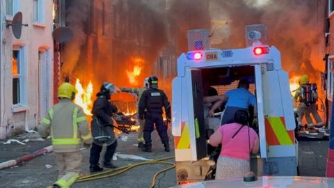 Police vehicle outside homes on fire 