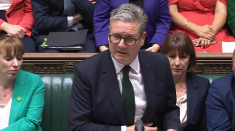 Sir Keir Starmer speaking in the House of Commons with other MPs behind him