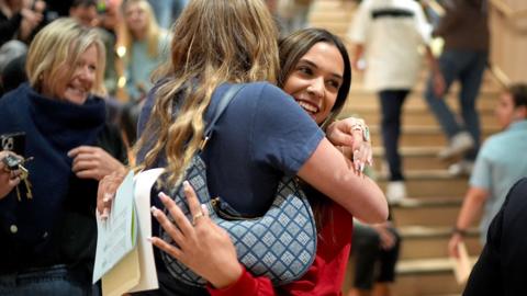 Pupil at Brighton College smiling and being hugged after openeing their GCSE results