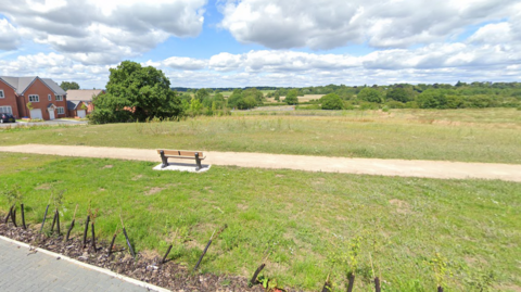 Bench on the edge of a housing estate overlooking fields