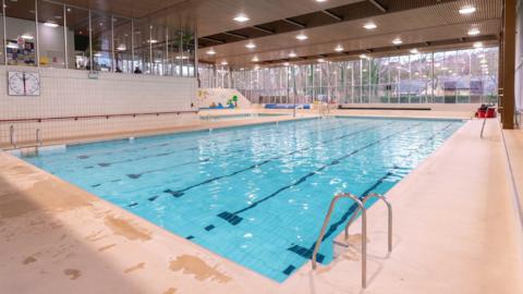 A large pool, housed in a modern leisure hub. 
