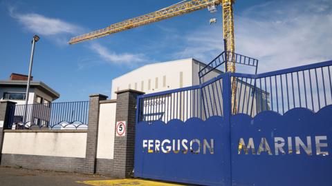 A blue gate at Ferguson shipyard with the words Ferguson Marine cut out 