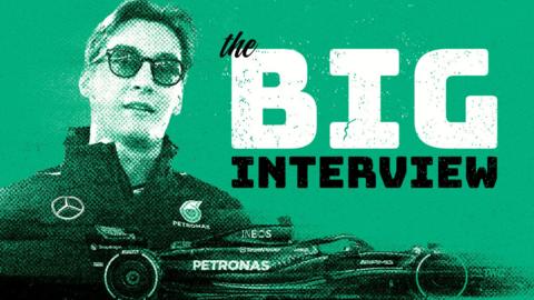 Graphic image of George Russell wearing sunglasses with a Mercedes F1 car in the front room. To the right of Russell is a graphic with the words 'The Big Interview'. It is all on a green background