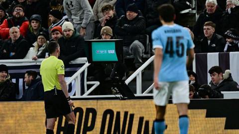 Chris Kavanagh at the pitch-side VAR monitor 