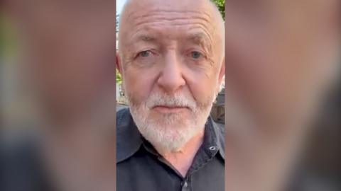 Bowen looks into the camera as he films himself selfie-style.