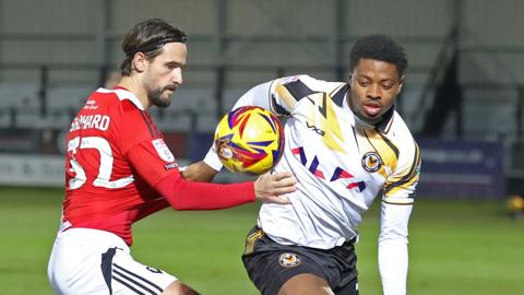 Salford City's Liam Shephard (L) battles for possession with Newport County's Bobby Kamwa