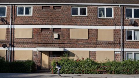 Windows in empty flats have been plugged with panels. 