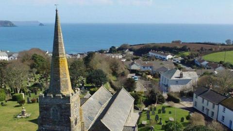 A drone photograph of the Spire on top of the church overlooking Gerrans Bay