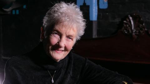 A smiling Peggy Seeger posing for the cover of her new album Teleology.