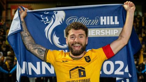 Jamie Brandon with the Scottish Premiership Play-off flag