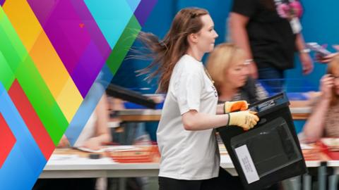 A young person runs with a ballot box