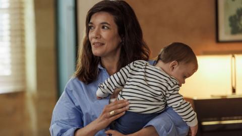 A woman holding a baby
