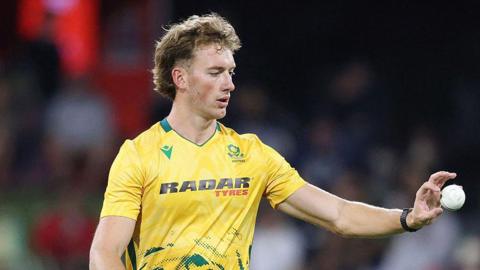 Dian Forrester in yellow South Africa shirt catches a ball with low palm thrown back to him