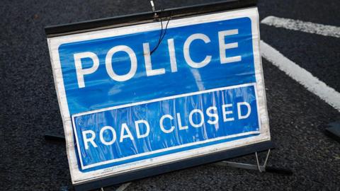 A police sign placed on a road.