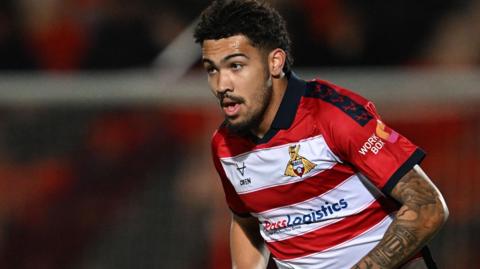 Frankie Okoronkwo in action for Doncaster Rovers in their red-and-white striped home shirt